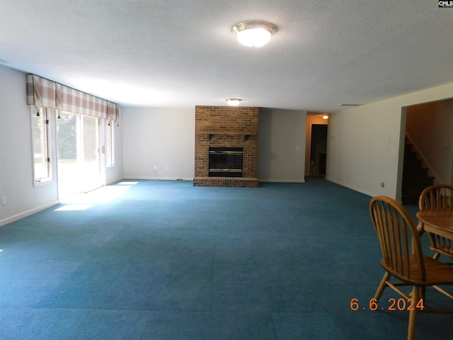 living room with a textured ceiling and a brick fireplace