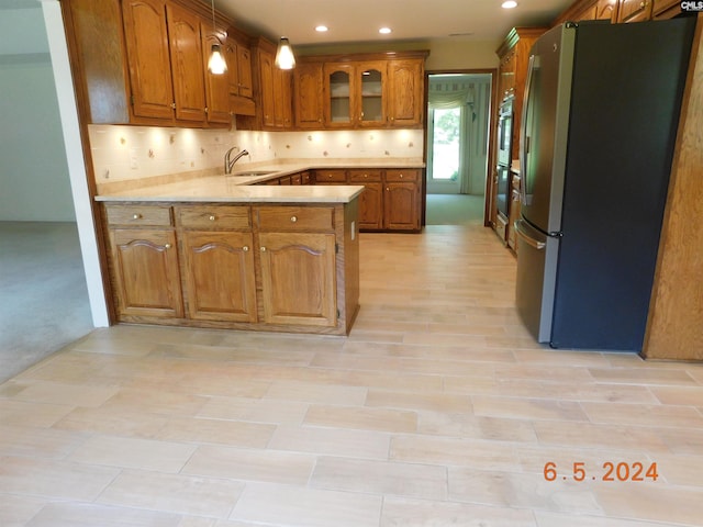 kitchen featuring light carpet, sink, appliances with stainless steel finishes, tasteful backsplash, and kitchen peninsula