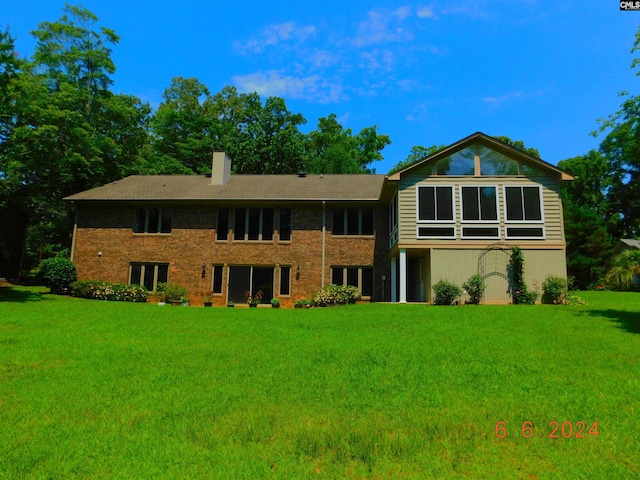 rear view of property with a lawn