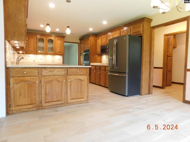 kitchen with decorative backsplash, decorative light fixtures, a chandelier, and black appliances