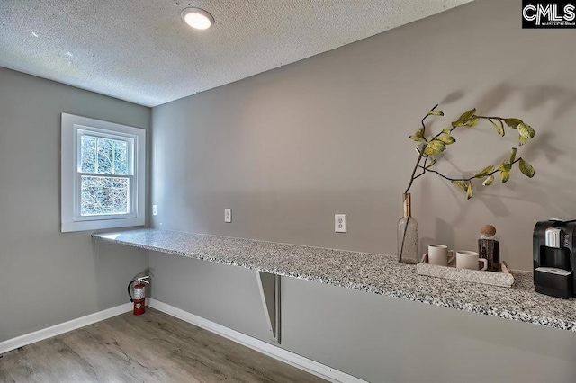 laundry area featuring hardwood / wood-style floors and a textured ceiling