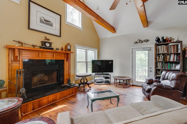 living area with a wealth of natural light, light wood-style flooring, high vaulted ceiling, and beamed ceiling