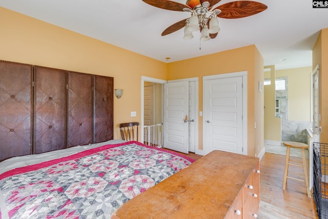 bedroom with light wood-style floors, ceiling fan, and baseboards