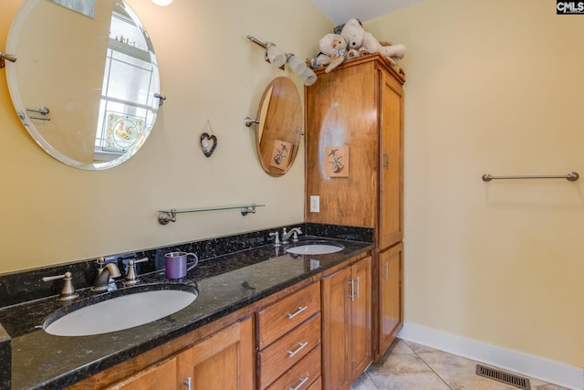 bathroom with double vanity, visible vents, a sink, and tile patterned floors