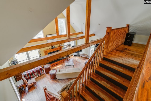 staircase featuring lofted ceiling and wood finished floors