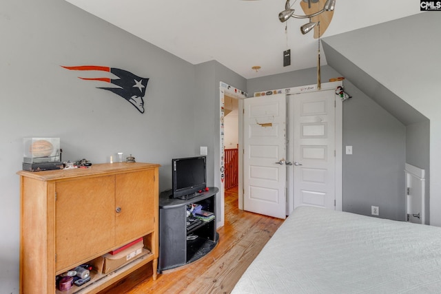 bedroom featuring lofted ceiling and light wood finished floors