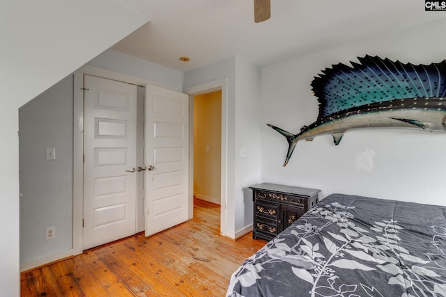 bedroom featuring ceiling fan, baseboards, and wood finished floors