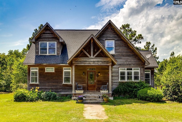 log cabin featuring a porch and a front lawn