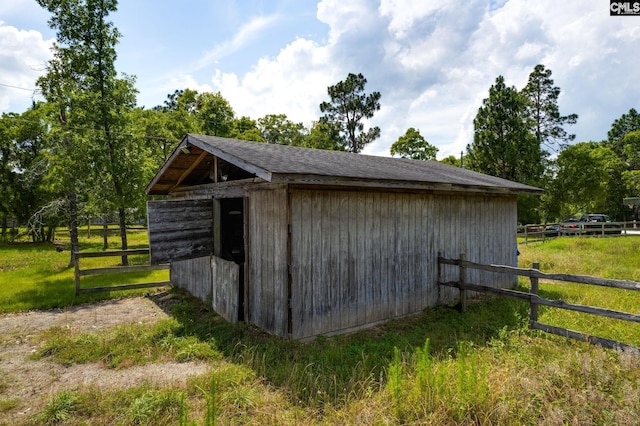 view of outdoor structure with a rural view and an outbuilding