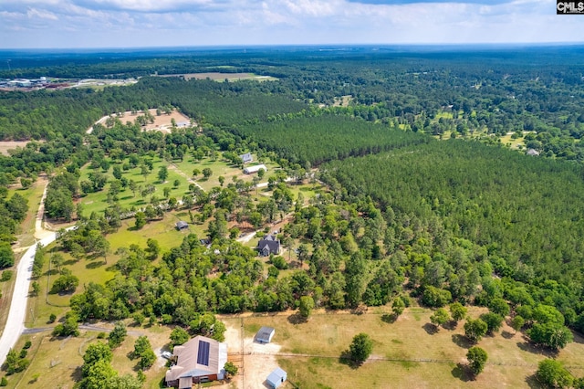 bird's eye view with a wooded view