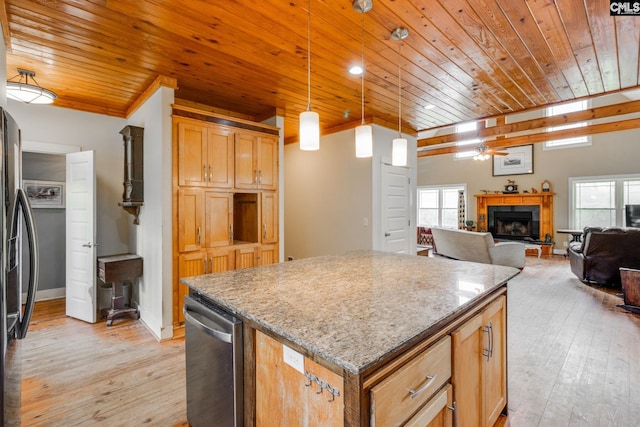 kitchen featuring a fireplace, a kitchen island, open floor plan, hanging light fixtures, and light wood-type flooring