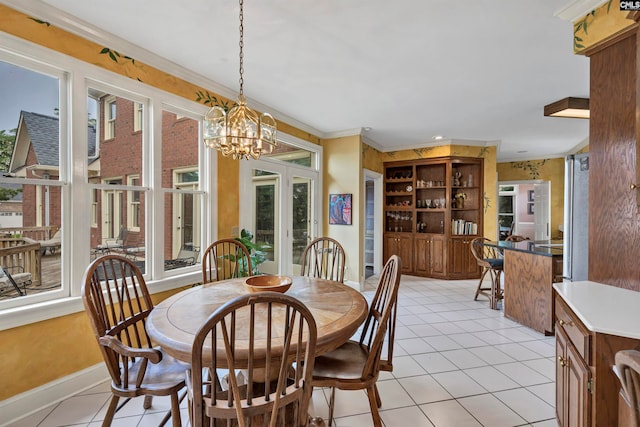 tiled dining space with a healthy amount of sunlight, ornamental molding, and an inviting chandelier