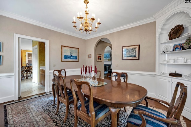 dining space with a chandelier, ornamental molding, and light hardwood / wood-style floors