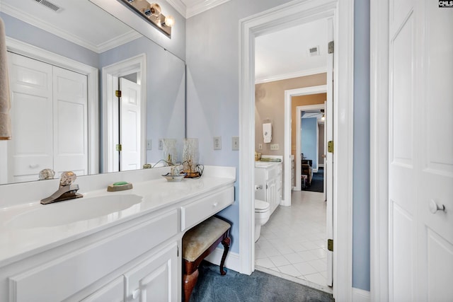 bathroom with tile flooring, ornamental molding, vanity, and toilet