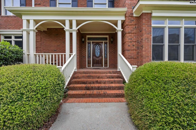 view of exterior entry featuring covered porch