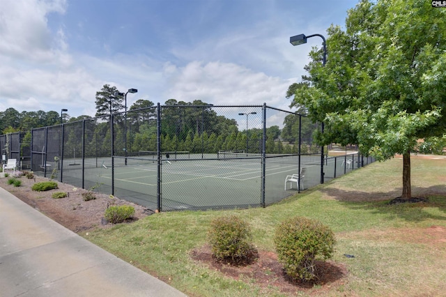 view of sport court featuring a lawn