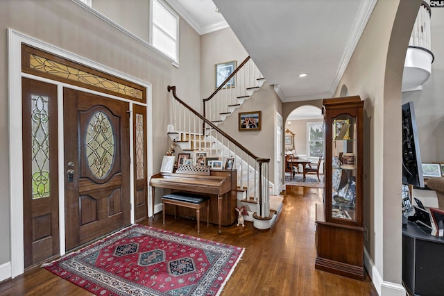 foyer featuring crown molding, hardwood / wood-style flooring, and a high ceiling