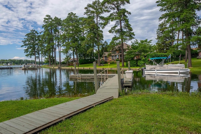 view of dock with a lawn and a water view