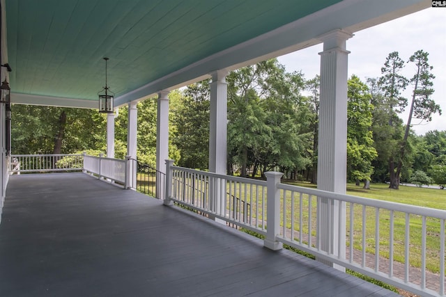 deck with a porch and a yard