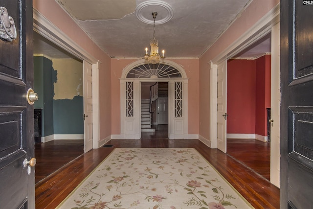 corridor with a chandelier and dark hardwood / wood-style floors