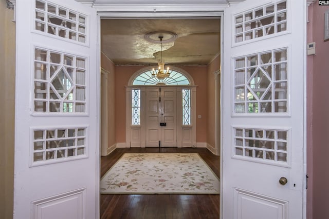 foyer entrance with a notable chandelier and dark hardwood / wood-style flooring