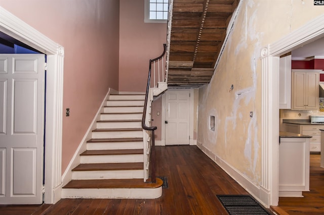 stairway featuring wood-type flooring and a high ceiling