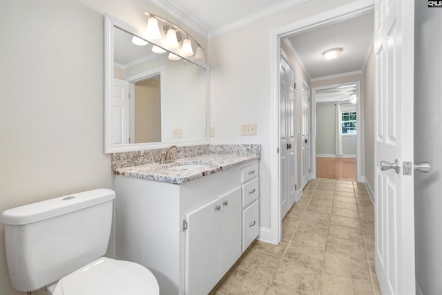 bathroom with ornamental molding, vanity, and toilet