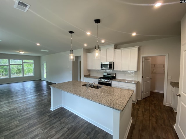 kitchen with a kitchen island with sink, hanging light fixtures, stainless steel appliances, and white cabinets