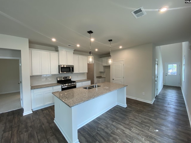 kitchen featuring decorative light fixtures, white cabinetry, an island with sink, sink, and stainless steel appliances