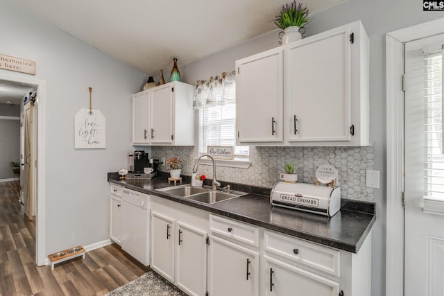 kitchen featuring white cabinets, dark wood-type flooring, dishwasher, and sink