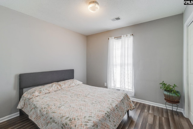 bedroom featuring dark wood-type flooring and multiple windows