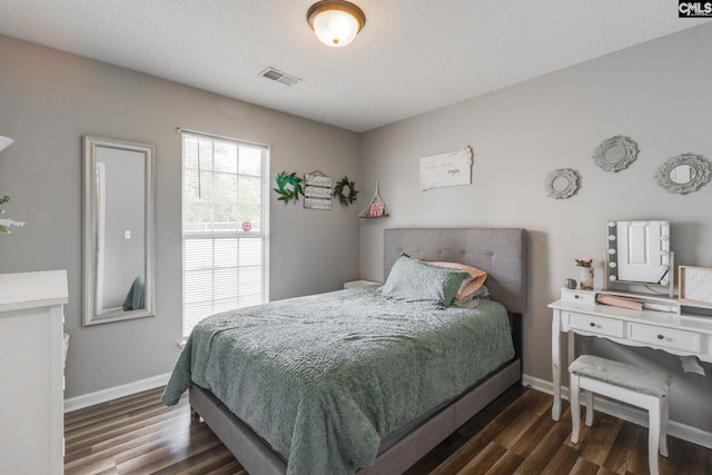 bedroom featuring dark wood-type flooring and a textured ceiling