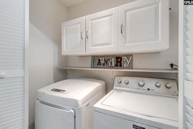 laundry room featuring washer and clothes dryer and cabinets