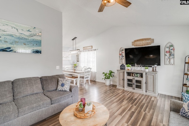 living room featuring ceiling fan, hardwood / wood-style floors, and vaulted ceiling