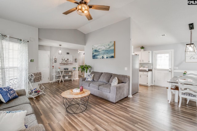 living room featuring hardwood / wood-style flooring, plenty of natural light, ceiling fan, and vaulted ceiling