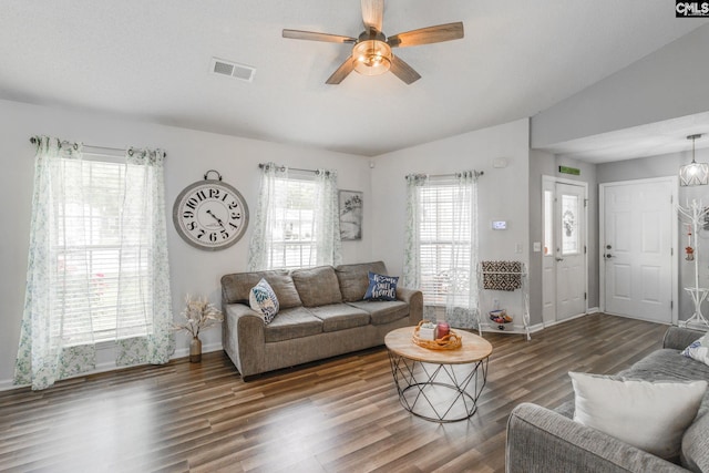 living room featuring dark hardwood / wood-style floors, ceiling fan, and vaulted ceiling