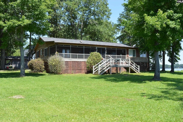 rear view of house featuring a sunroom and a yard