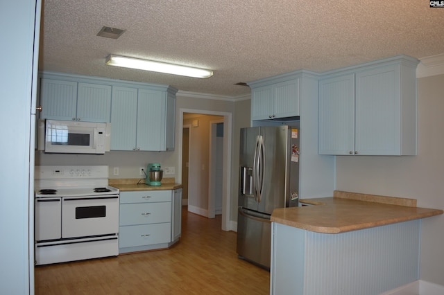 kitchen featuring white appliances, ornamental molding, a textured ceiling, light hardwood / wood-style floors, and kitchen peninsula