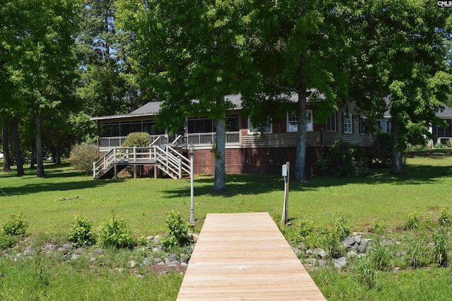 rear view of property with a lawn and a sunroom