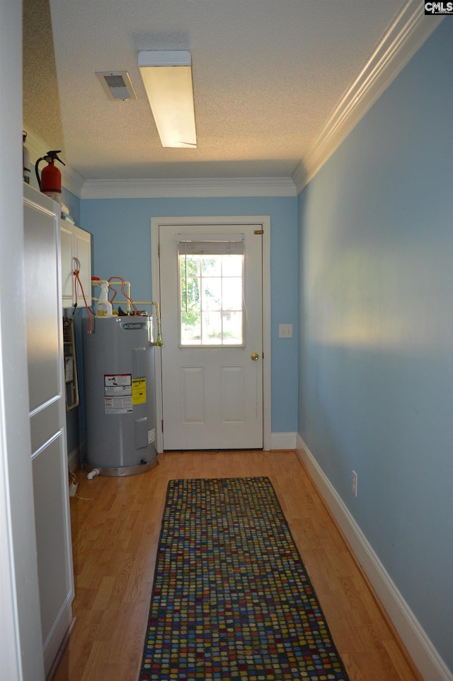 entryway featuring a textured ceiling, electric water heater, light hardwood / wood-style flooring, and ornamental molding