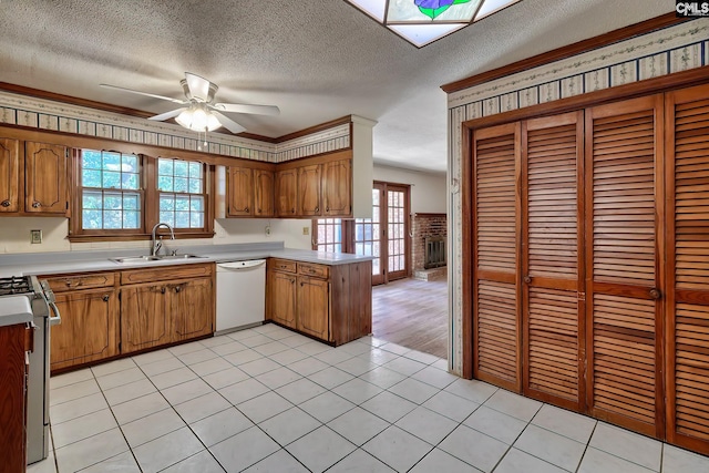 kitchen featuring stainless steel stove, dishwasher, light tile patterned floors, sink, and ceiling fan