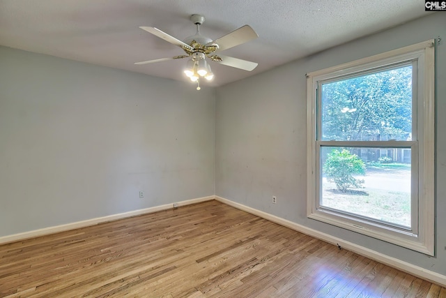 unfurnished room featuring plenty of natural light, ceiling fan, and light hardwood / wood-style floors