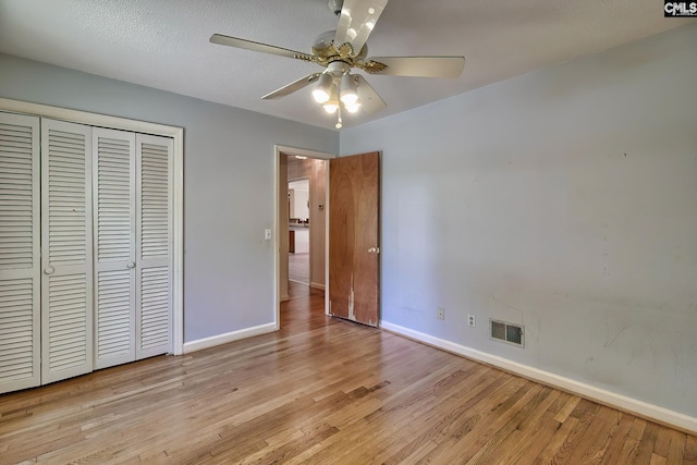 unfurnished bedroom with a closet, ceiling fan, light hardwood / wood-style flooring, and a textured ceiling