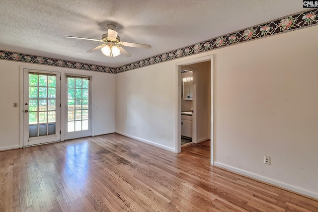 empty room with light wood-type flooring, a textured ceiling, and ceiling fan