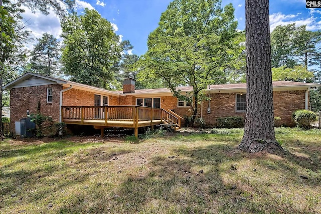 rear view of house featuring a lawn and a wooden deck