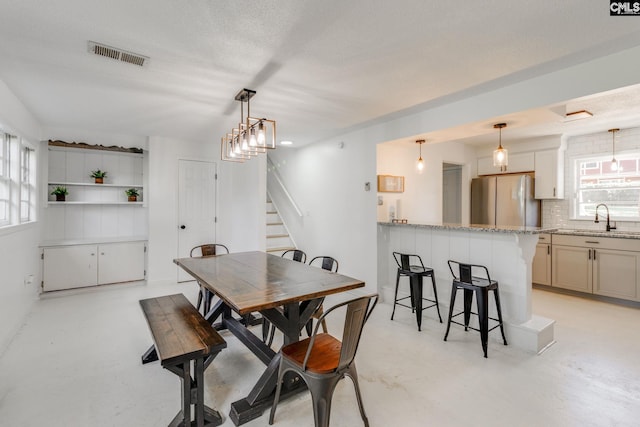 dining area with a healthy amount of sunlight, a textured ceiling, and sink