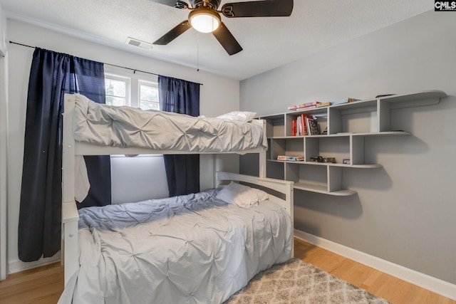 bedroom featuring a textured ceiling, ceiling fan, and light hardwood / wood-style flooring