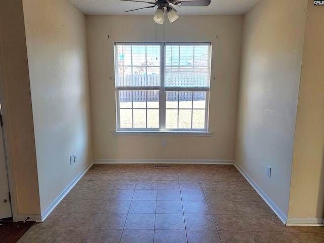 tiled empty room with ceiling fan and a healthy amount of sunlight