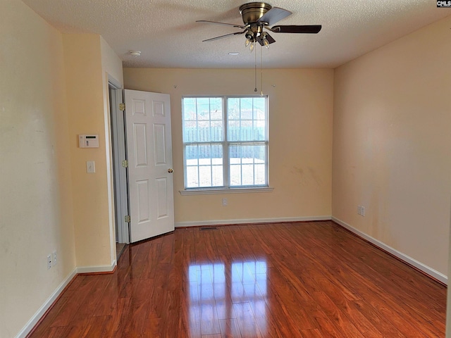 spare room with dark hardwood / wood-style flooring, ceiling fan, and a textured ceiling