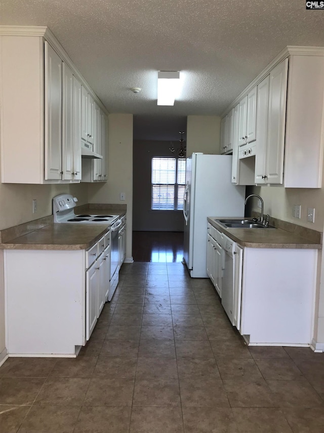 kitchen with a textured ceiling, white appliances, white cabinetry, and sink